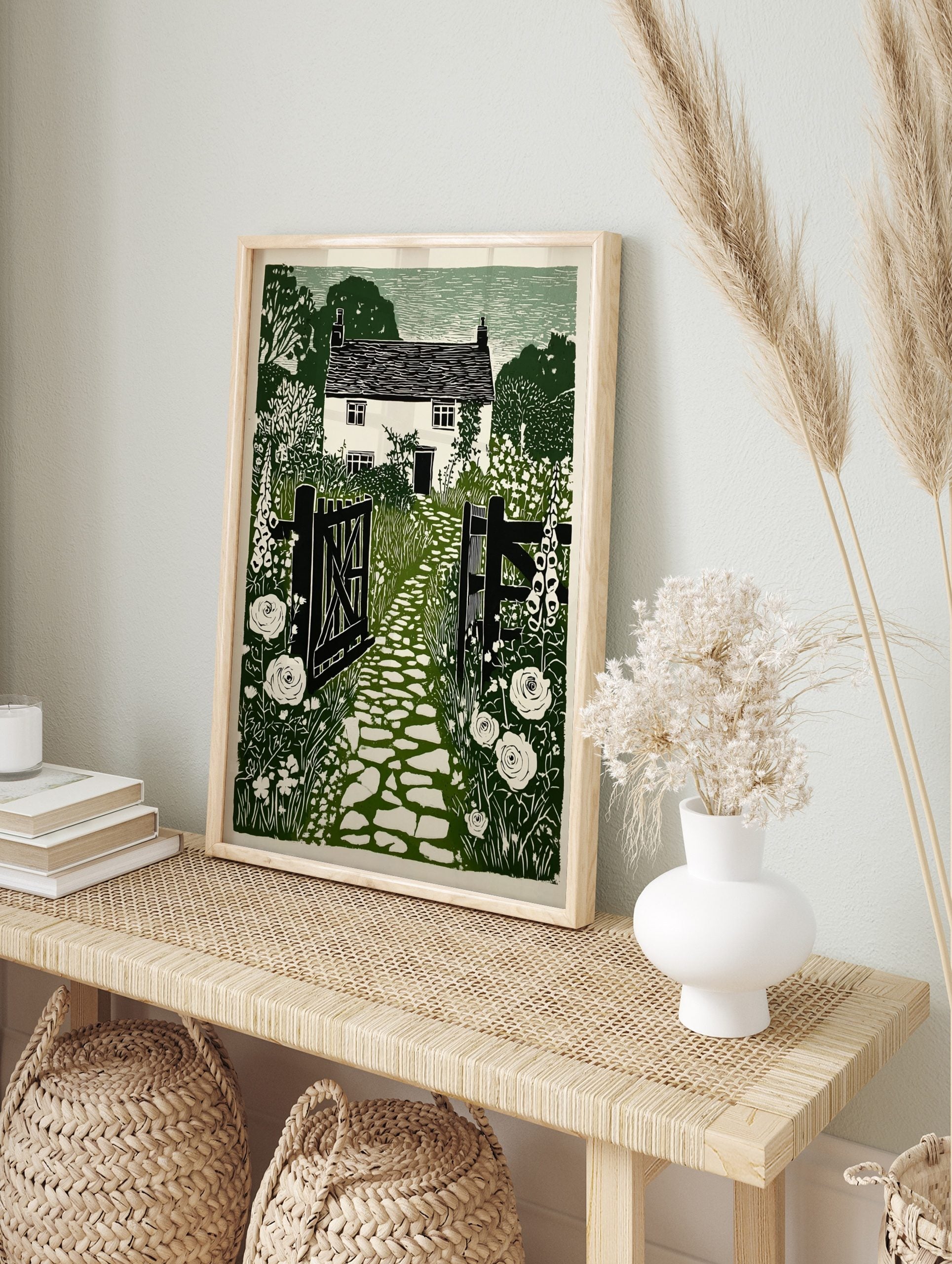 Green linocut print of a British cottage garden with open gate, cobbled path, foxgloves, and, in an alternate framed mockup