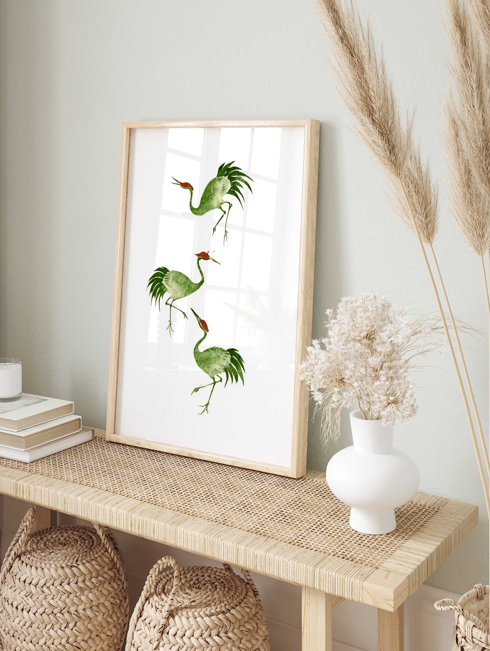 Three watercolour style green cranes with reddish crowns in a vertical arrangement on a white, in an alternate framed mockup