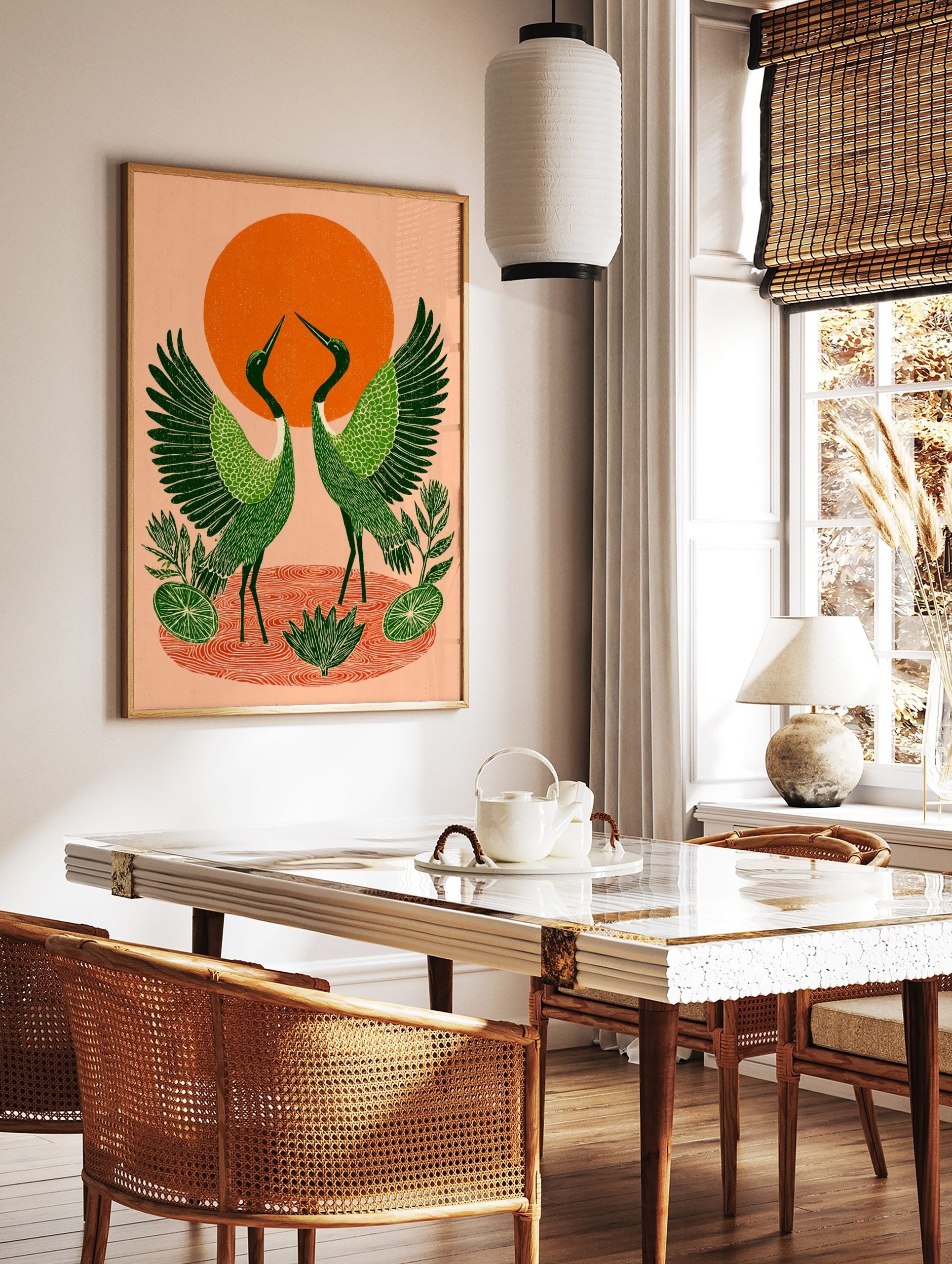 Illustrative green cranes with spread wings, orange sun, and water ripples print, in a styled room mockup