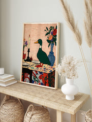 Illustrative green duck standing on a colourful table with a lit candle and flower vases, in an alternate framed mockup