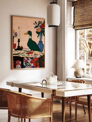 Illustrative green duck standing on a colourful table with a lit candle and flower vases, in a styled room mockup