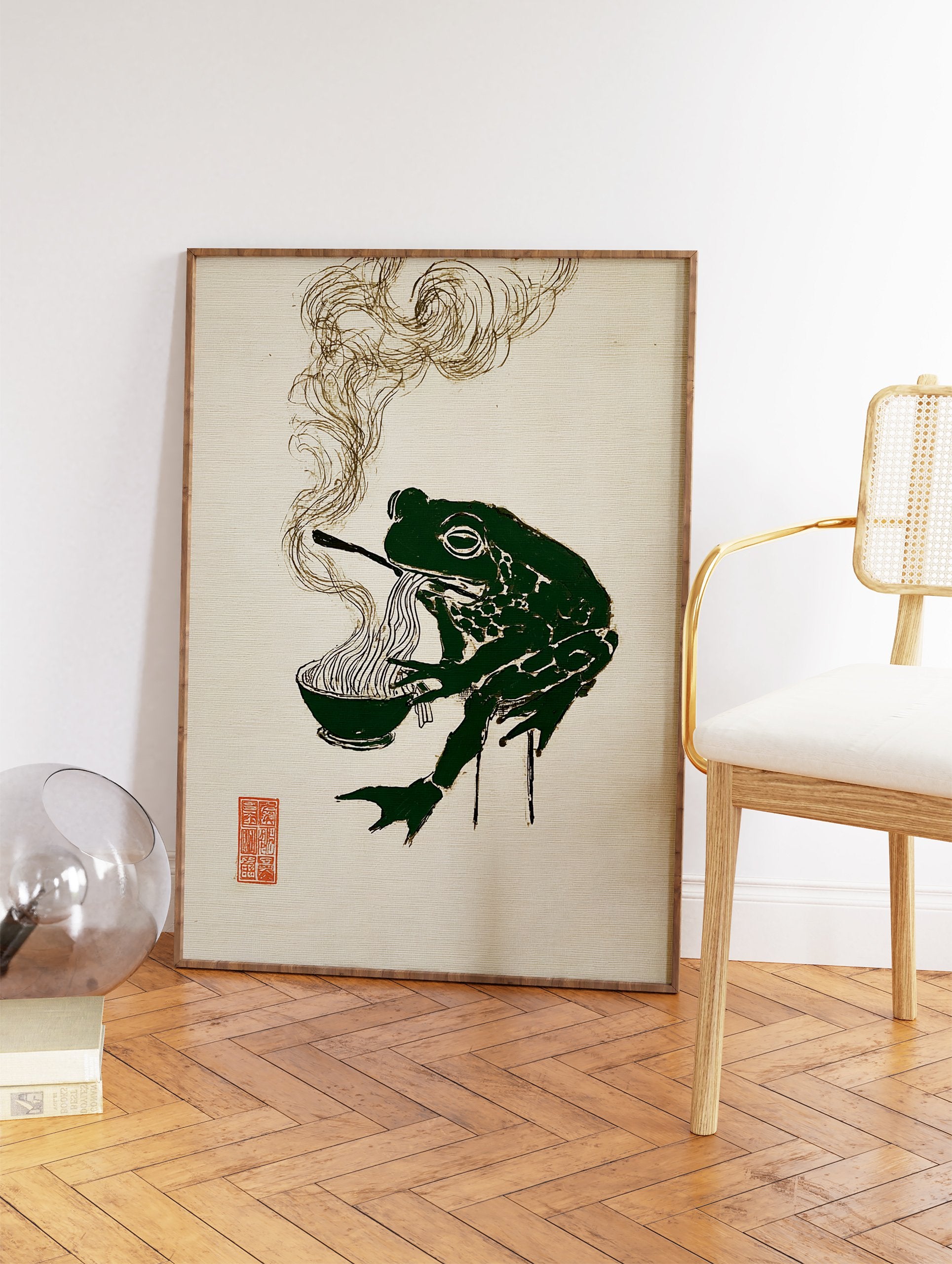 Stylized green frog eating ramen noodles with chopsticks, with steam rising, on a textured beige background. Green Frog Ramen Wall Art. - Image 2