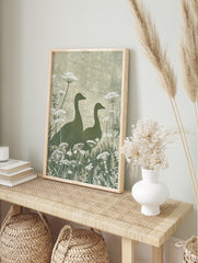 Illustrative green goose silhouettes with white Queen Anne's Lace botanical print, in an alternate framed mockup