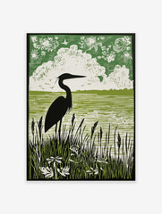 Green linocut style print of a heron in silhouette standing in tall reeds by water, with clouds and birds in the sky