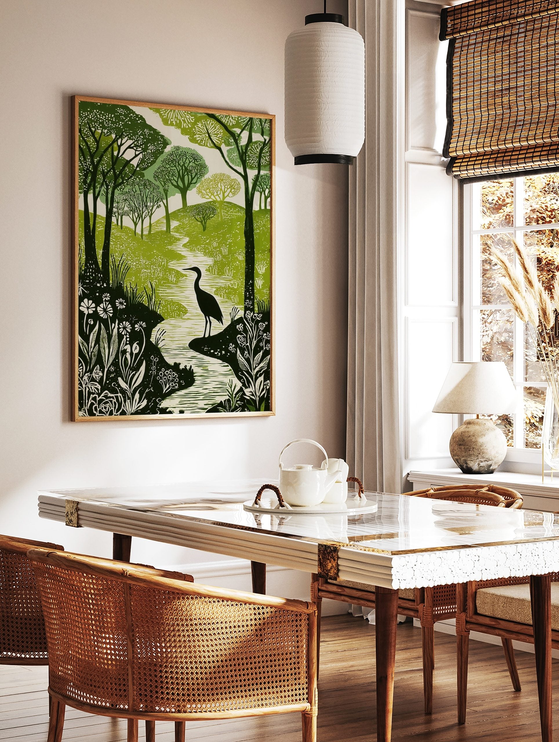 Green and white woodcut print of a heron in a winding river, surrounded by forest trees and, in a styled room mockup