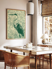 Illustrative green heron bird print standing in marsh grasses on a light beige background in, in a styled room mockup