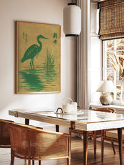 Green heron bird standing in water with reeds, Japanese characters, green and golden-tan colours, in a styled room mockup
