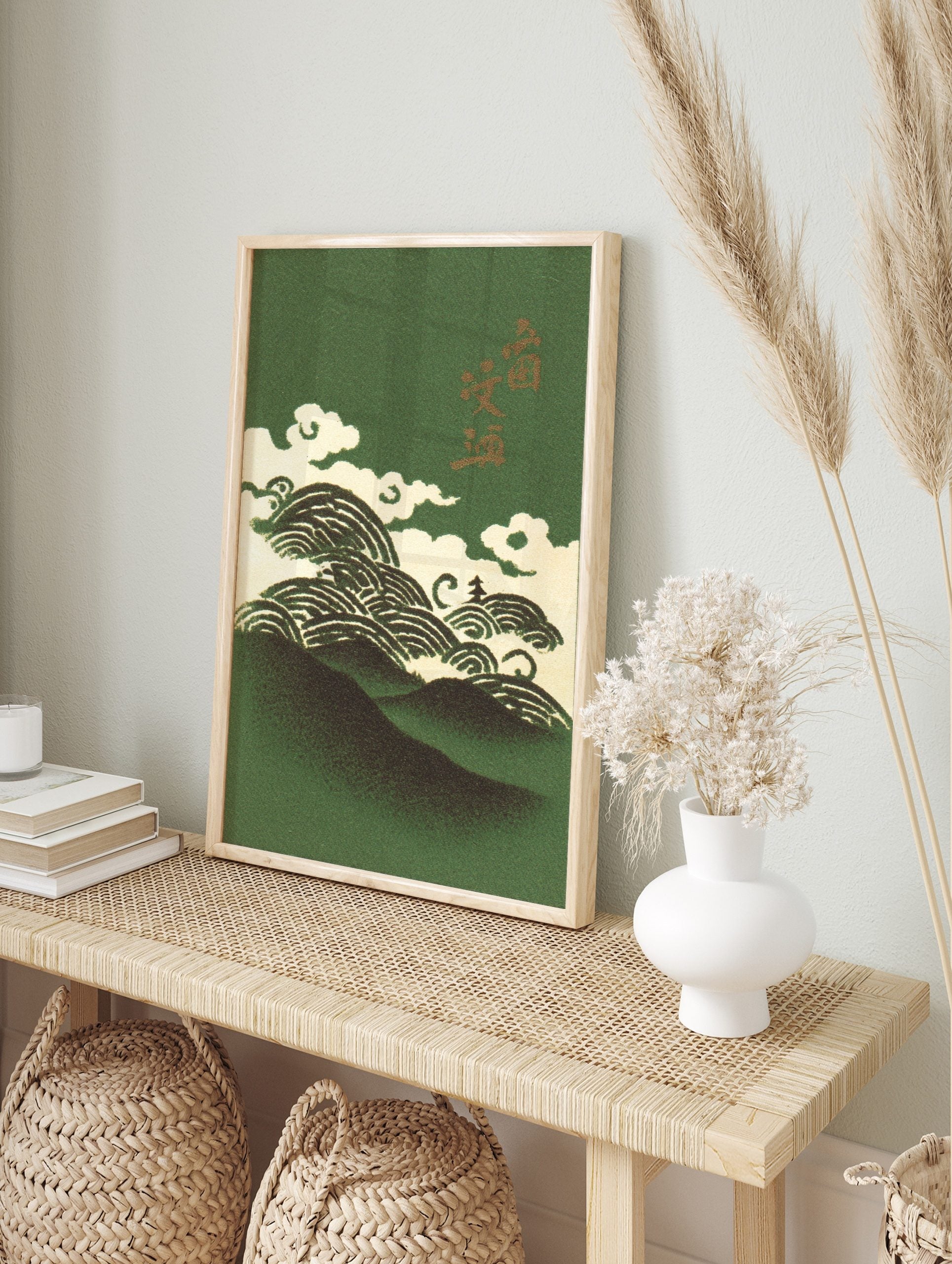 Illustrative Japanese art print with dark green mountains, cream waves, clouds, and gold, in an alternate framed mockup