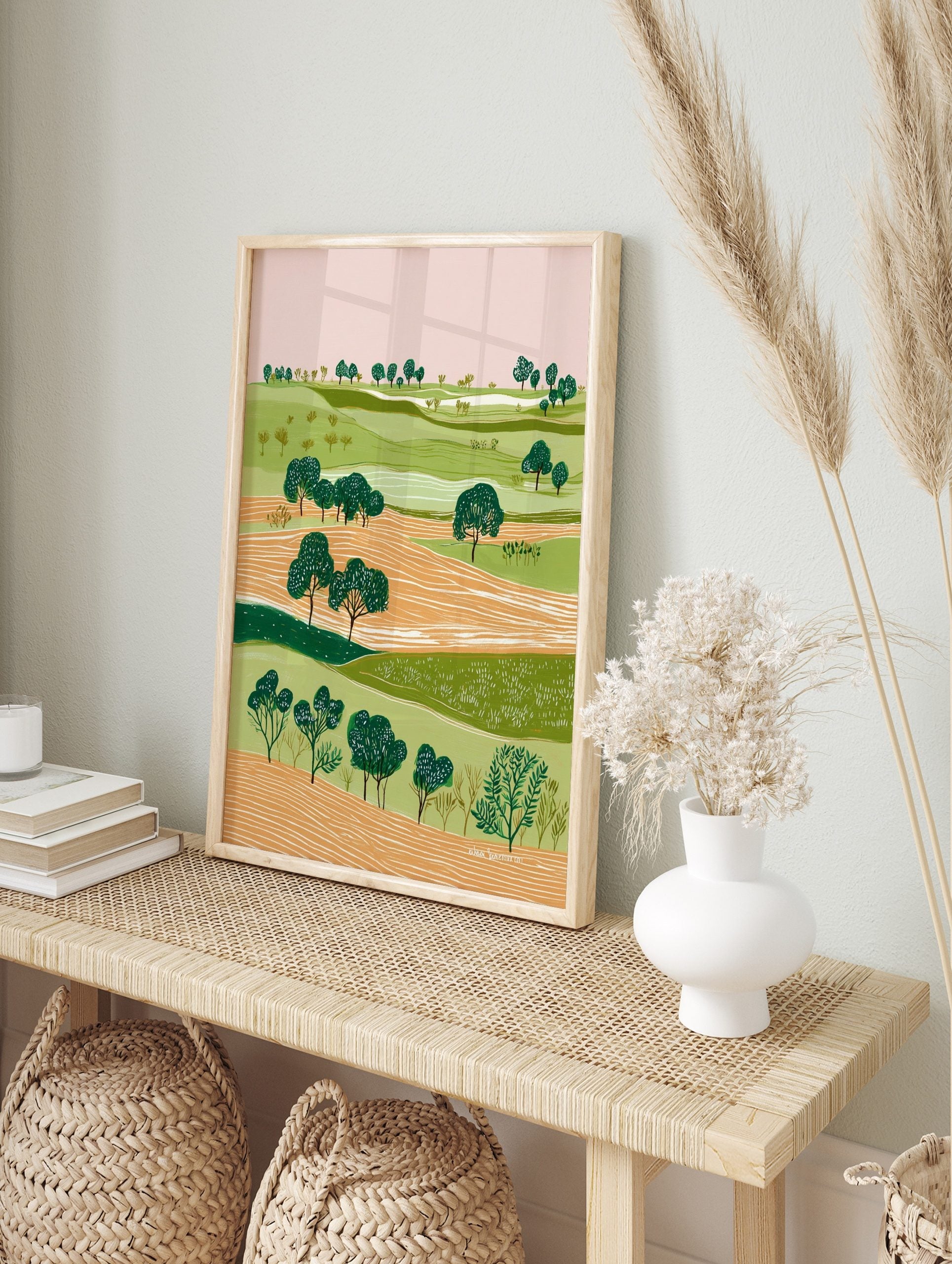 Illustrative green landscape art print with rolling hills, orange fields, and dark green, in an alternate framed mockup