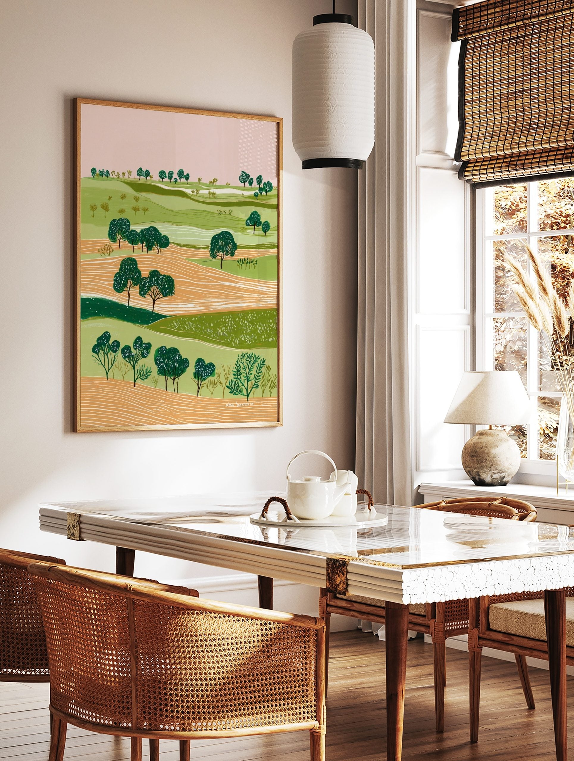 Illustrative green landscape art print with rolling hills, orange fields, and dark green trees, in a styled room mockup