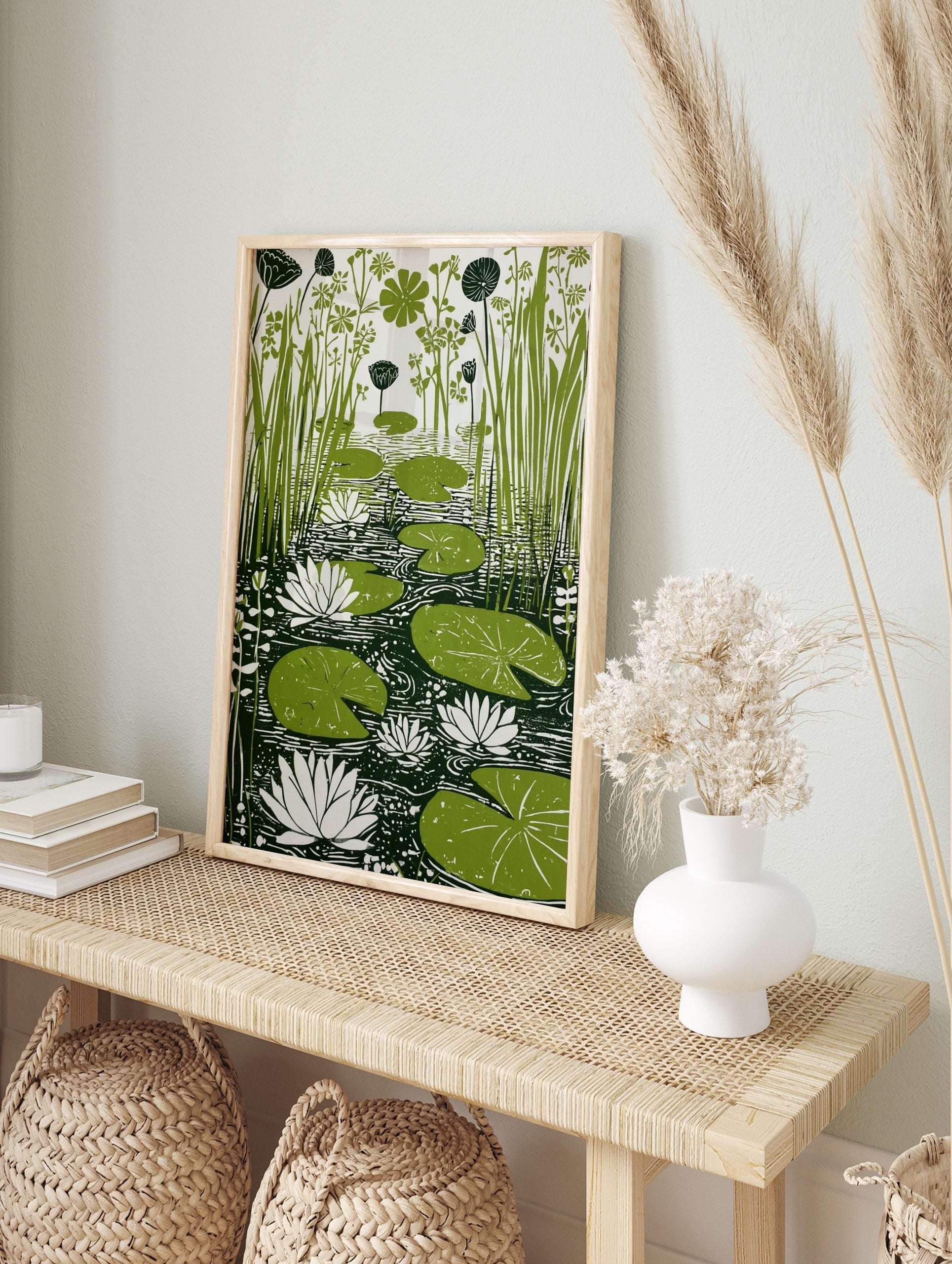 Green lily pads, white water lilies, and tall reeds in a pond, linocut-style botanical print, in an alternate framed mockup