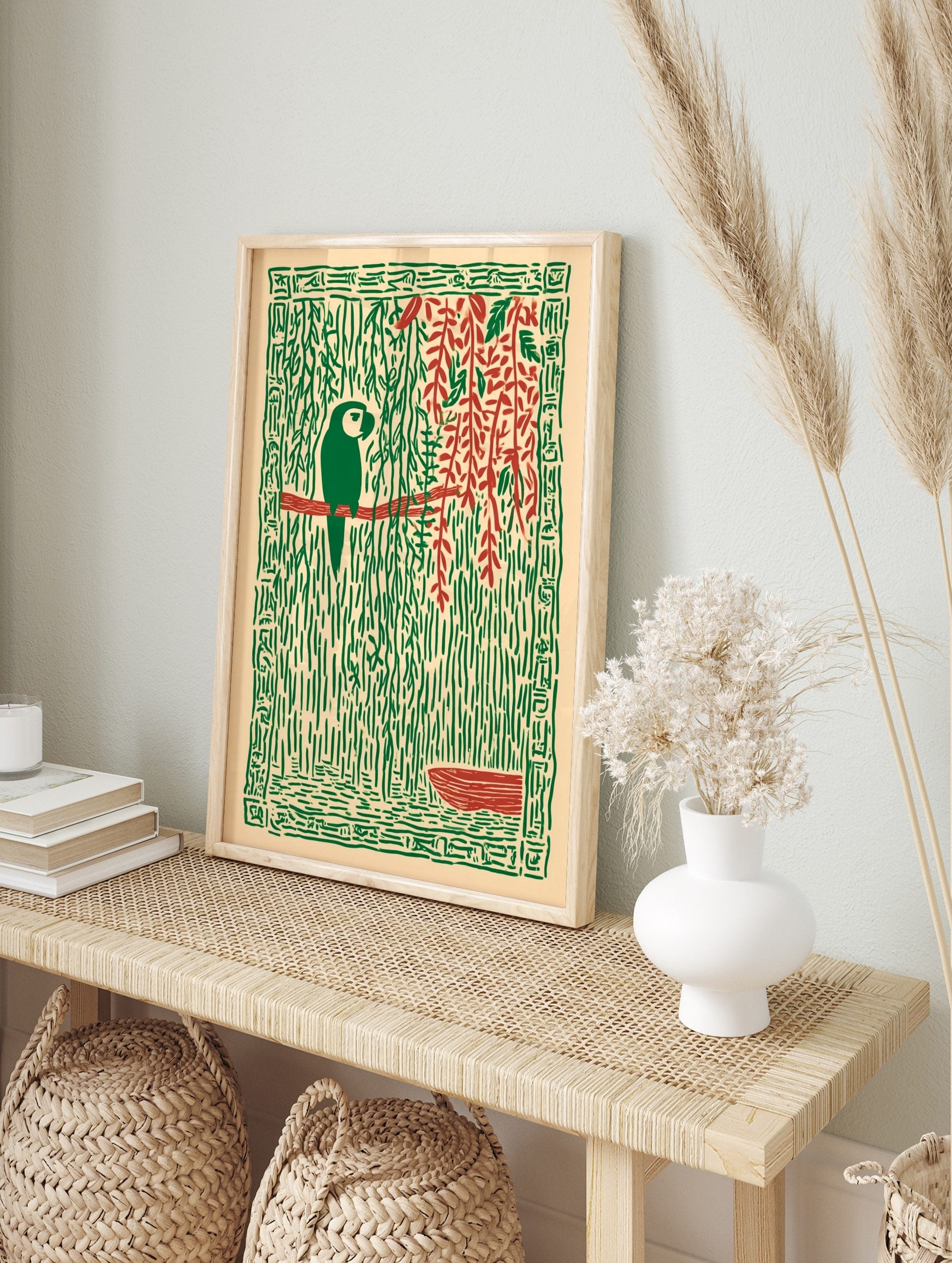 Stylised green parrot on red branch, surrounded by green jungle vines, red leaves, and a, in an alternate framed mockup