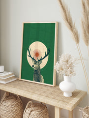 Illustrative green stag with antlers, set against a cream circle and red sunburst on a dark, in an alternate framed mockup