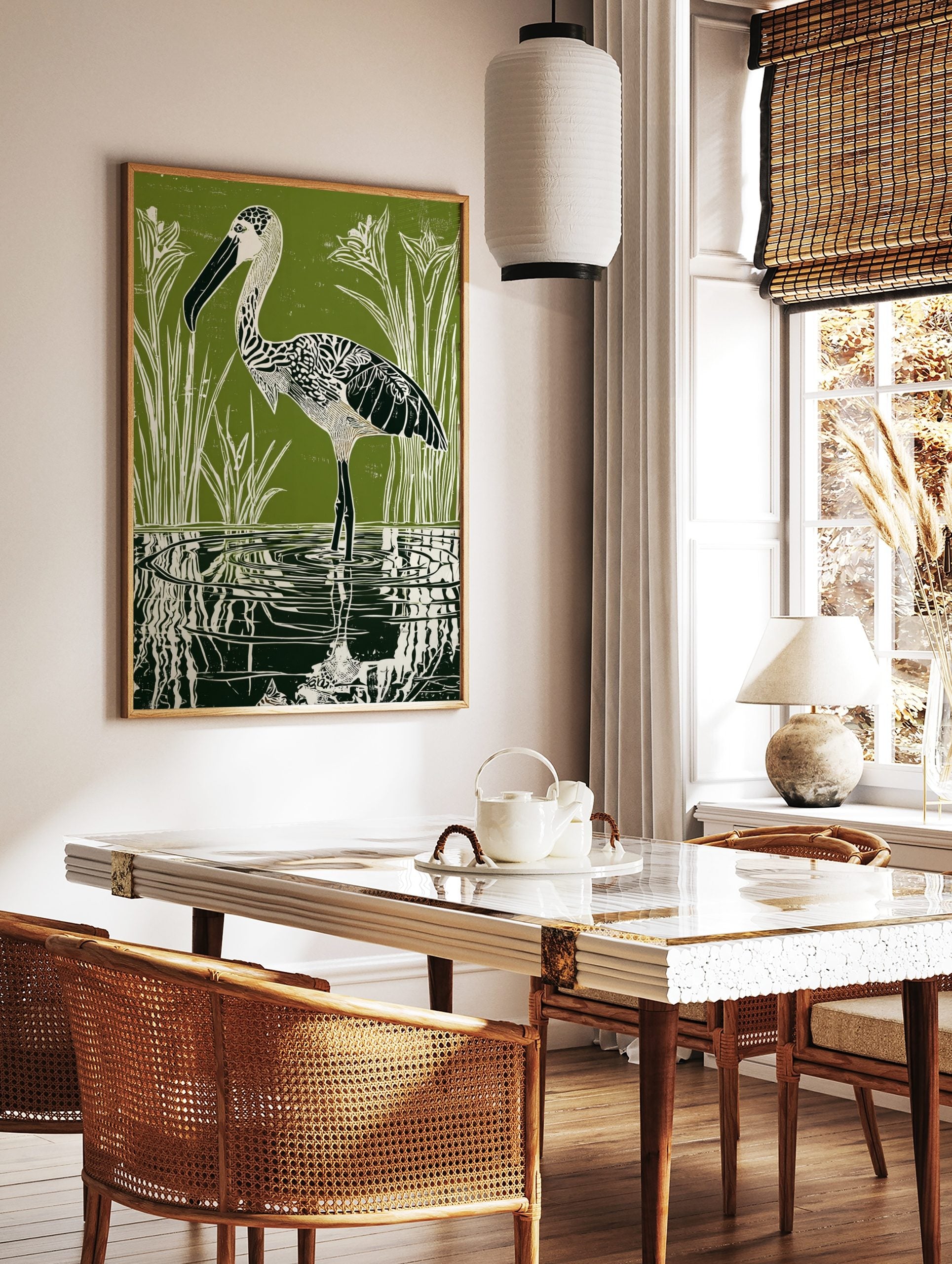 Green linocut print of a patterned stork wading in water with reeds and reflections, in a styled room mockup