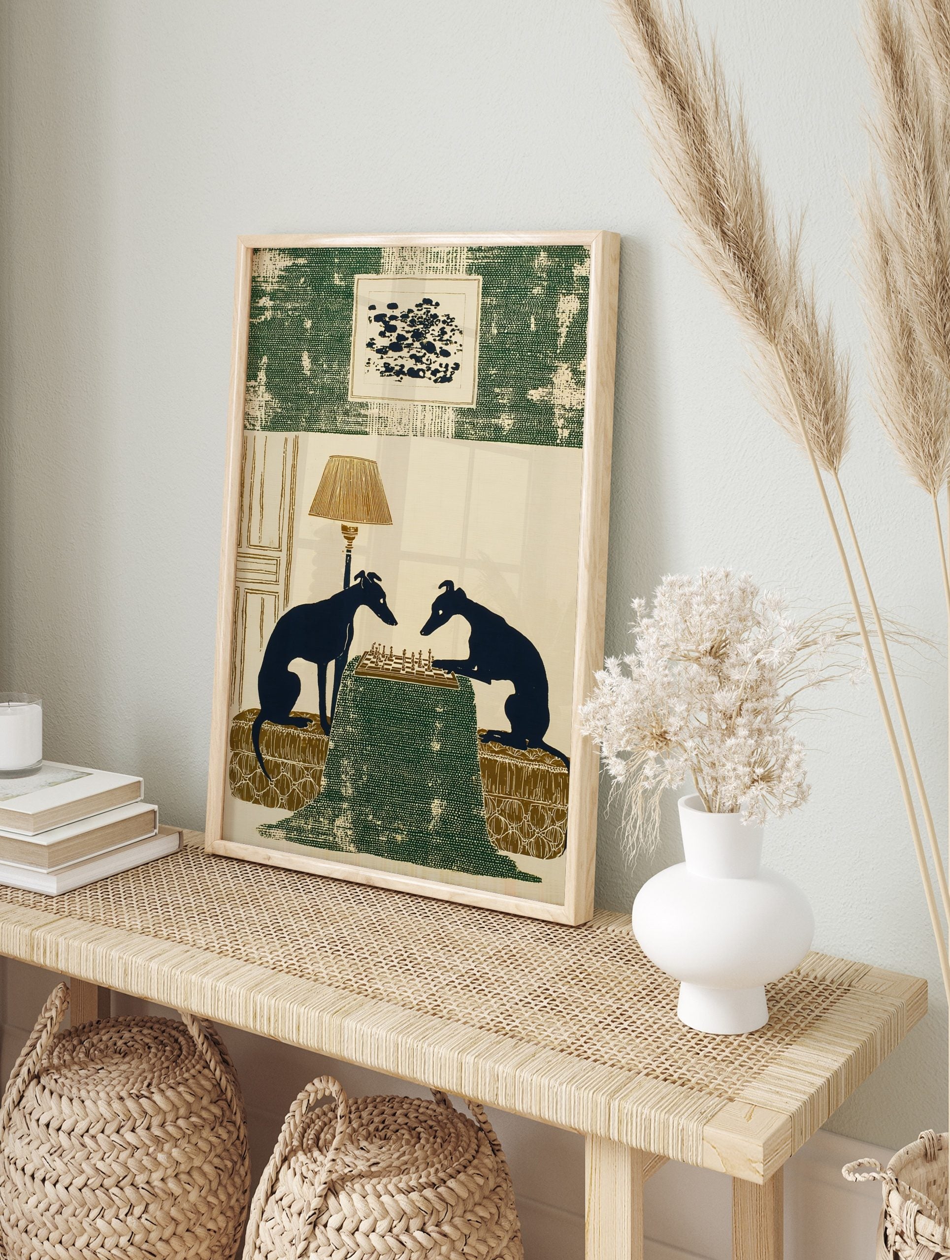 Illustrative print of two dark blue greyhound silhouettes playing chess on a green table with, in an alternate framed mockup