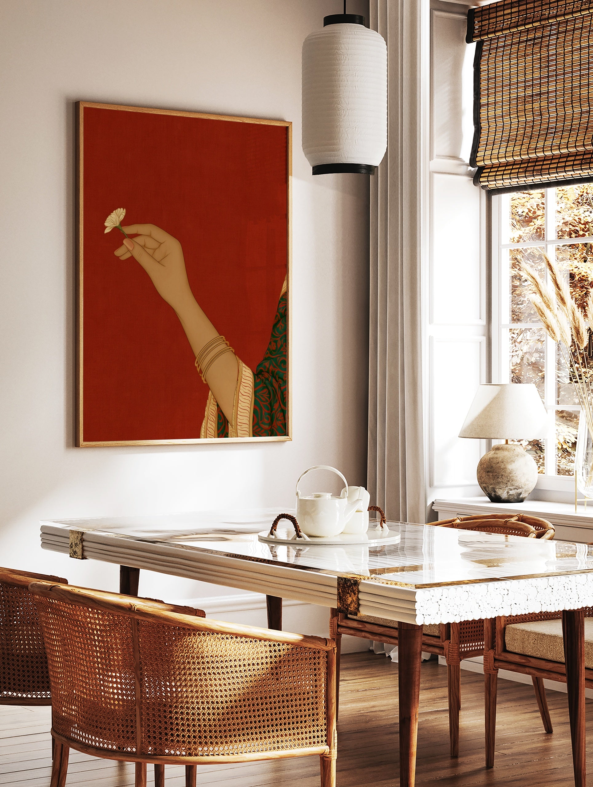 Illustrative art print of a hand holding a small flower, wearing gold bangles, set against a solid, in a styled room mockup