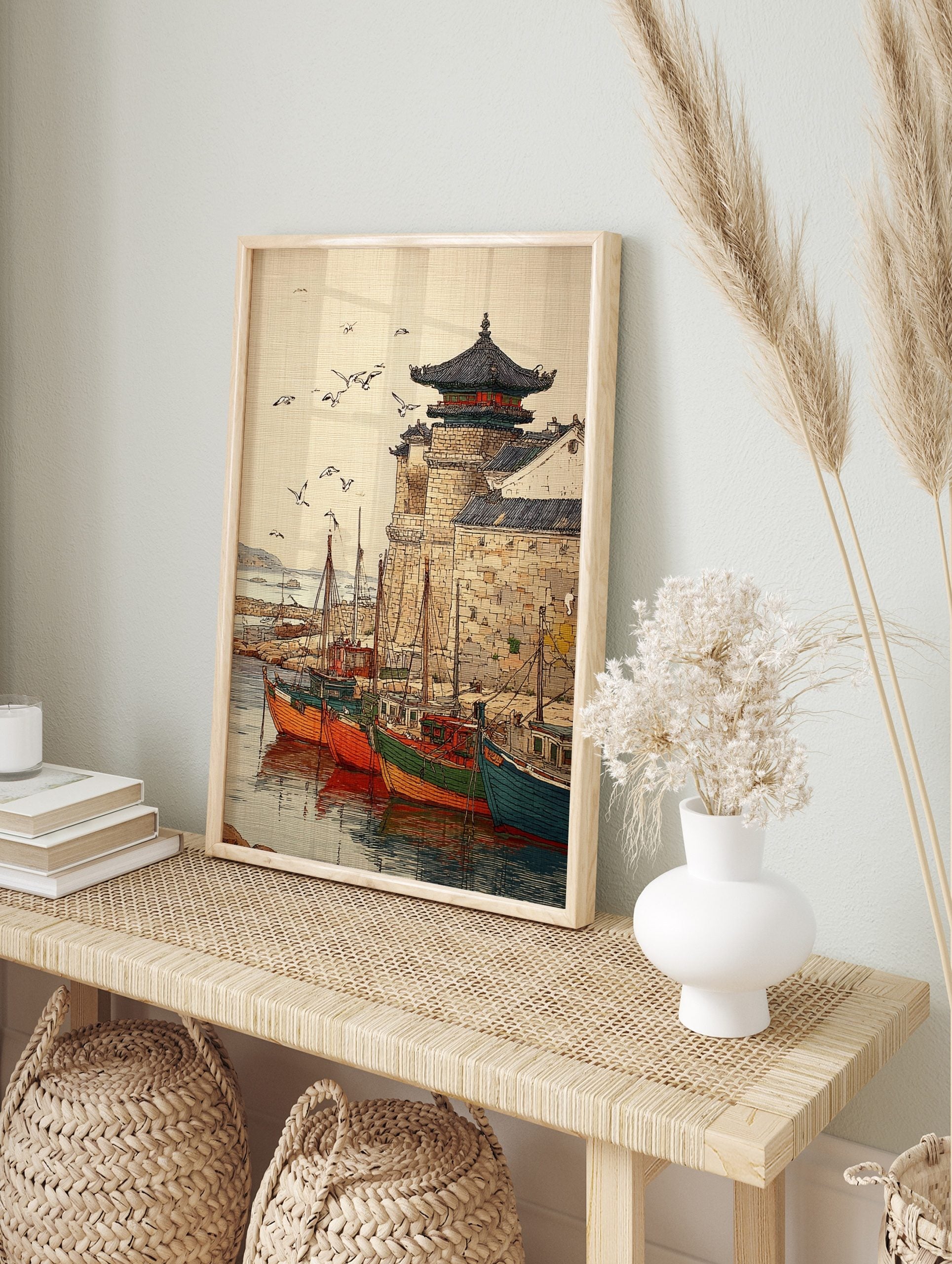 Illustrative print of an Asian harbour with colourful fishing boats, stone wall, pagoda, and, in an alternate framed mockup