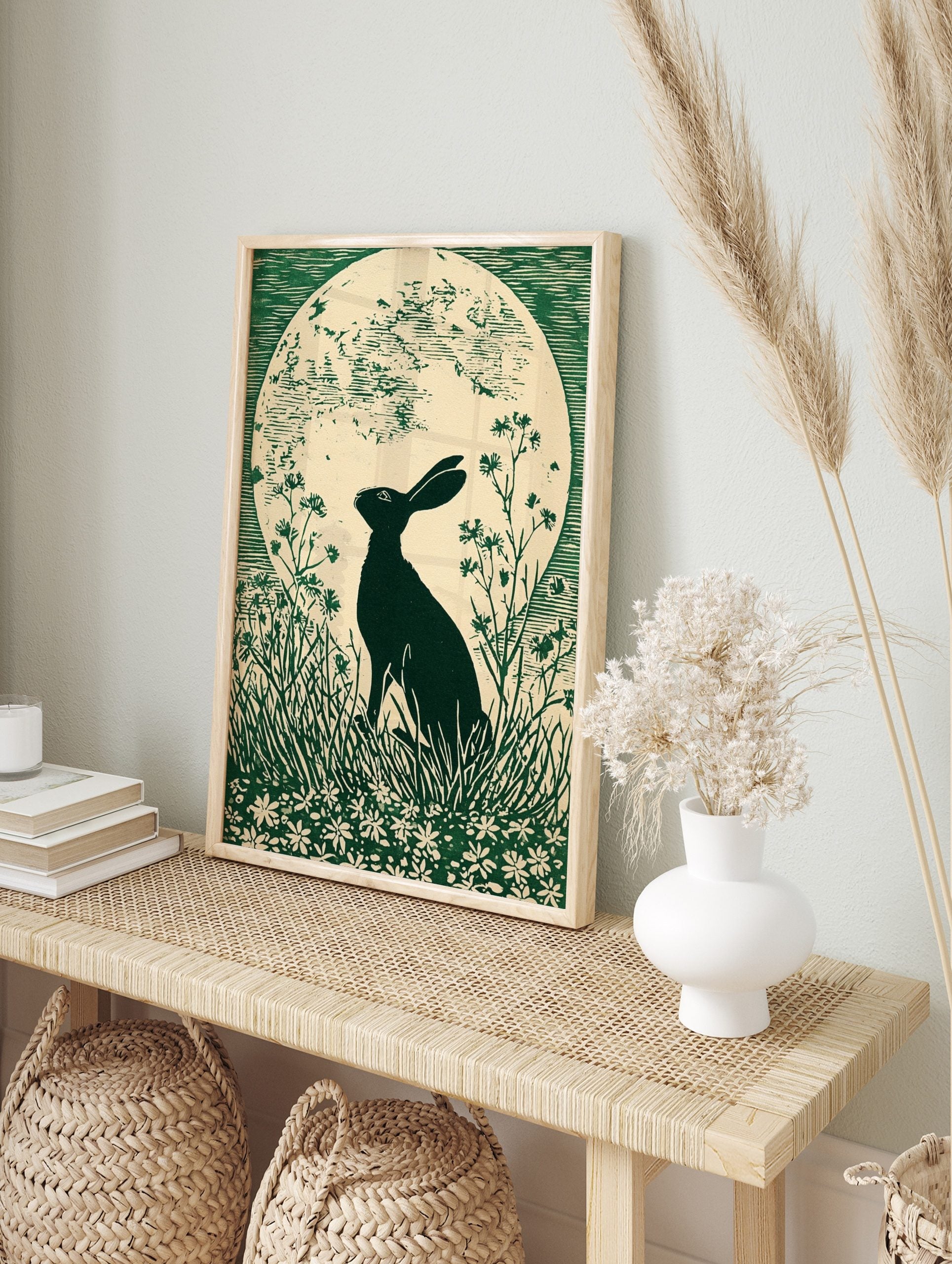 Green linocut print of a hare in silhouette looking at a large full moon, surrounded by grass, in an alternate framed mockup