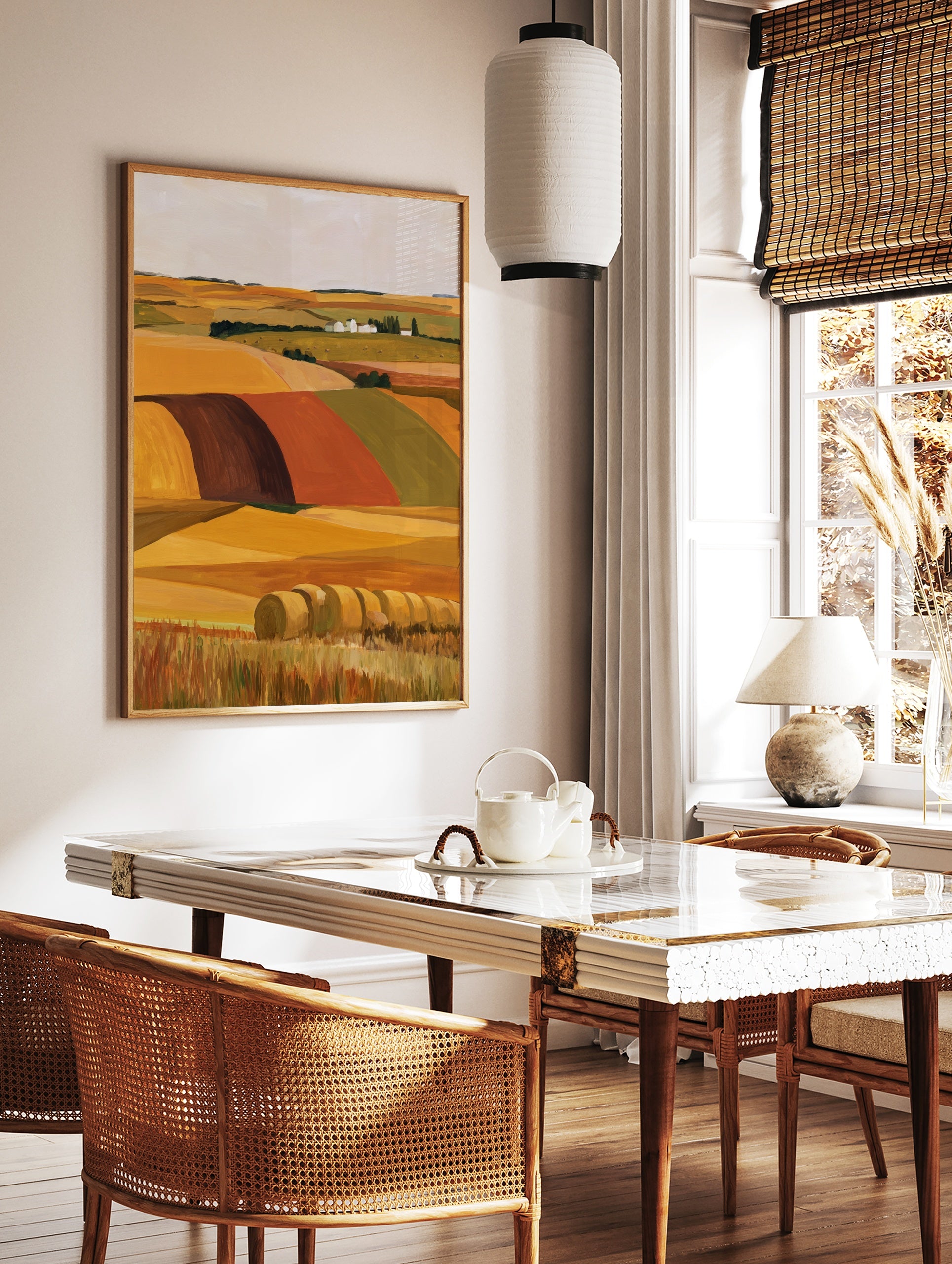 Illustrative landscape wall art of golden hay bales in a field with a distant farmstead and rolling, in a styled room mockup