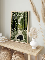 Linocut-style art print of a hedgehog on a winding path through a green forest with falling, in an alternate framed mockup