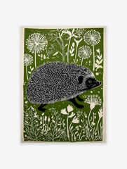 Linocut print of a hedgehog walking through a green and white stylized meadow with dandelion-like flowers.