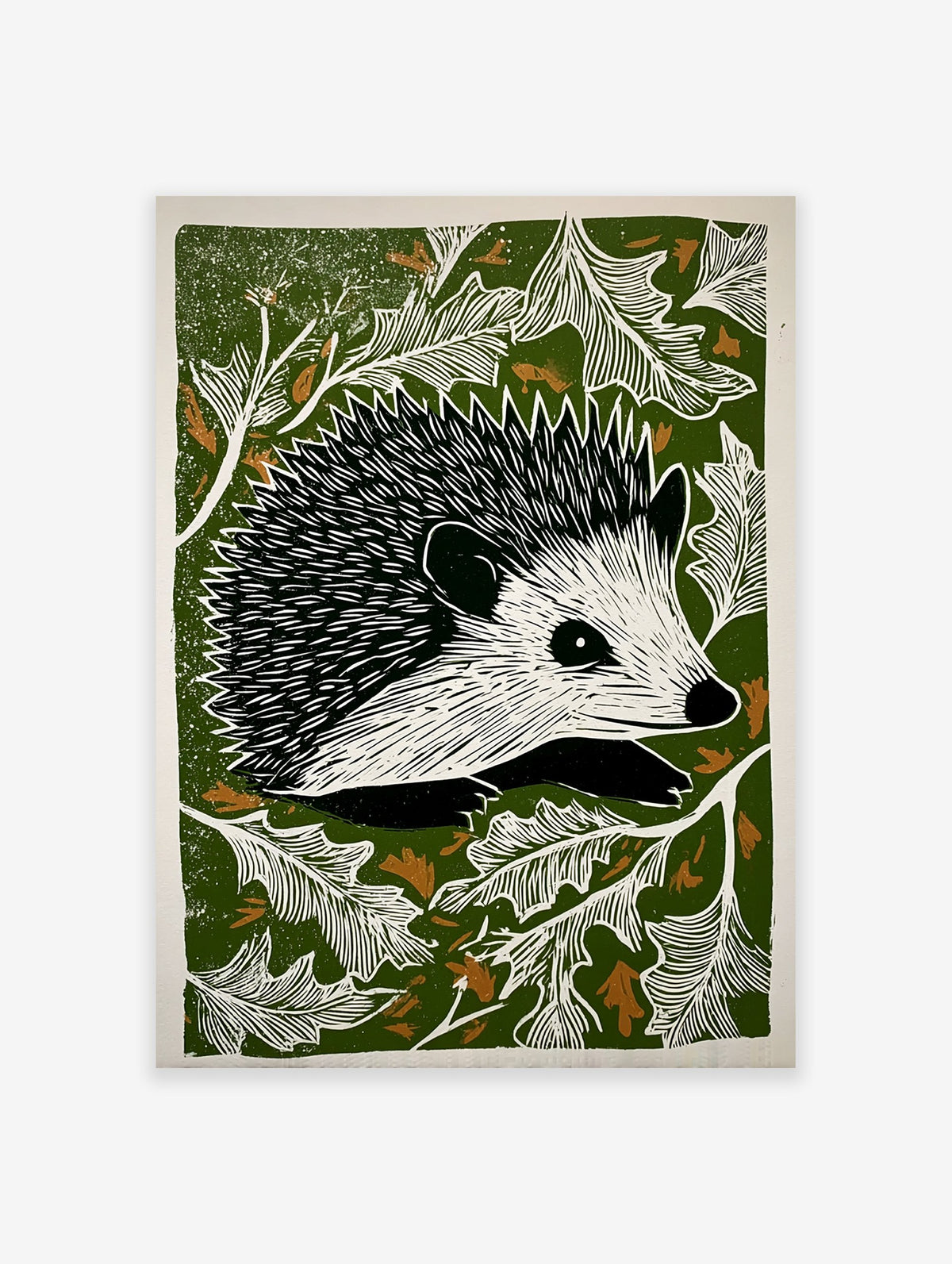 Hedgehog linocut print with black and white hedgehog surrounded by white leaves on a dark green background with brown accents.