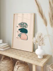 Three illustrative hedgehogs with floral, dotted, and striped patterns in teal and peach on a, in an alternate framed mockup