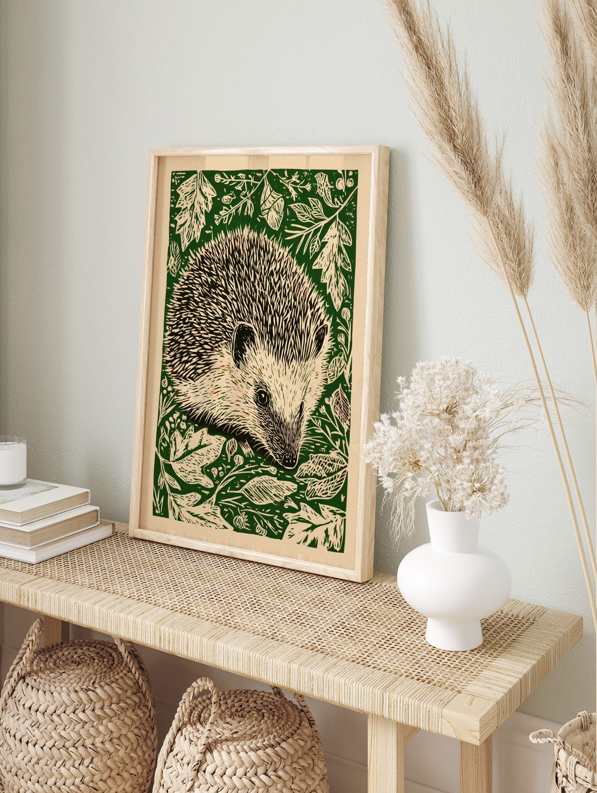 Hedgehog woodcut illustration wall art with quills and forest foliage on a green background, in an alternate framed mockup