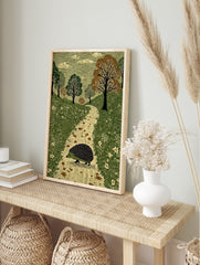 Illustrative print of a hedgehog walking on a path in a green woodland with trees and clouds, in an alternate framed mockup