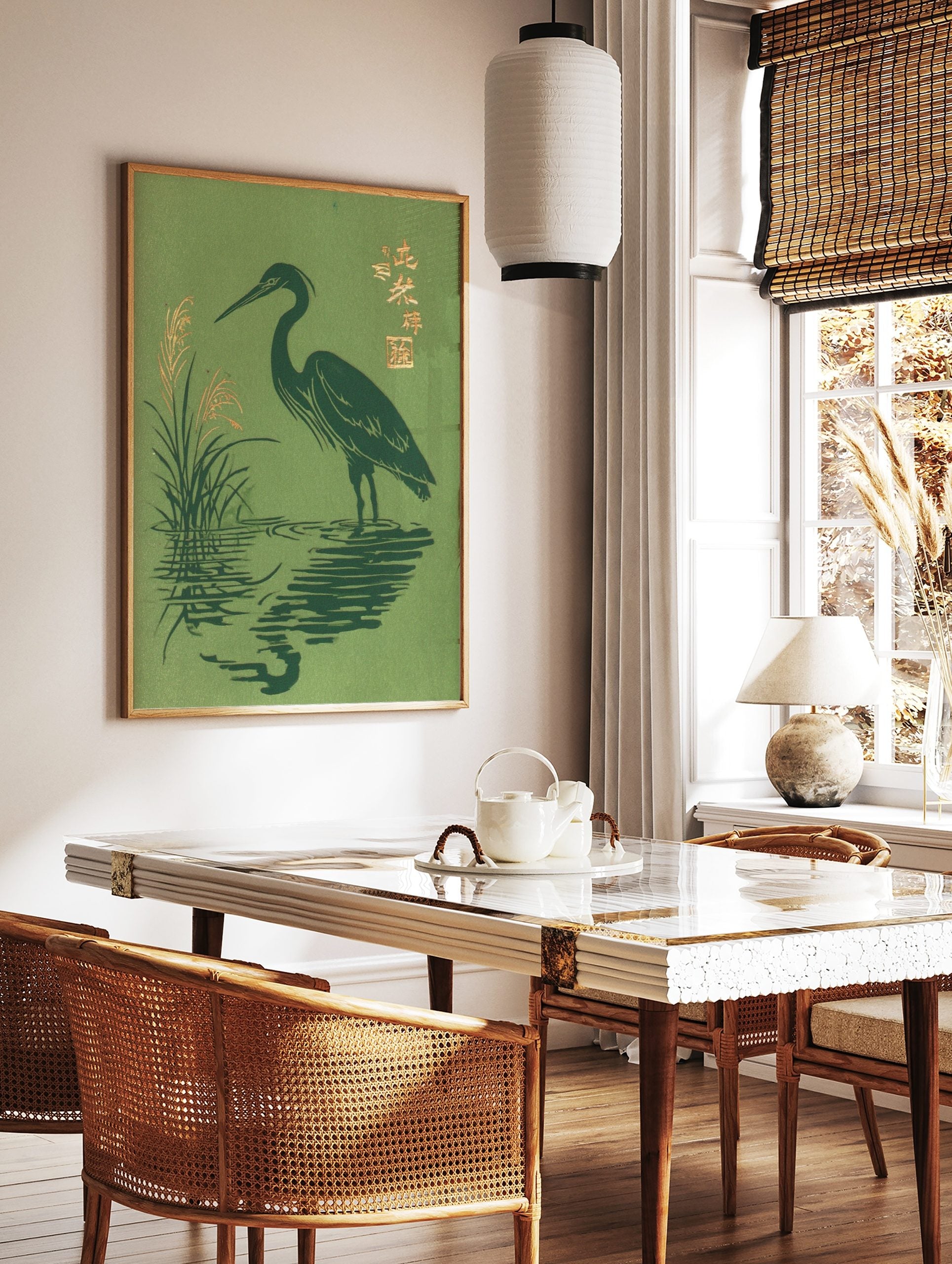 Japanese woodblock-style print of a dark green heron wading in water with golden reeds and kanji, in a styled room mockup