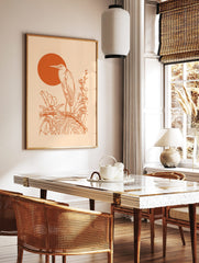 Orange line art of a heron bird on a branch with tropical leaves and a large orange sun on a beige, in a styled room mockup