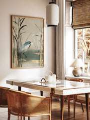 White heron bird standing among tall reeds with gold accents on a cream background, illustrative, in a styled room mockup