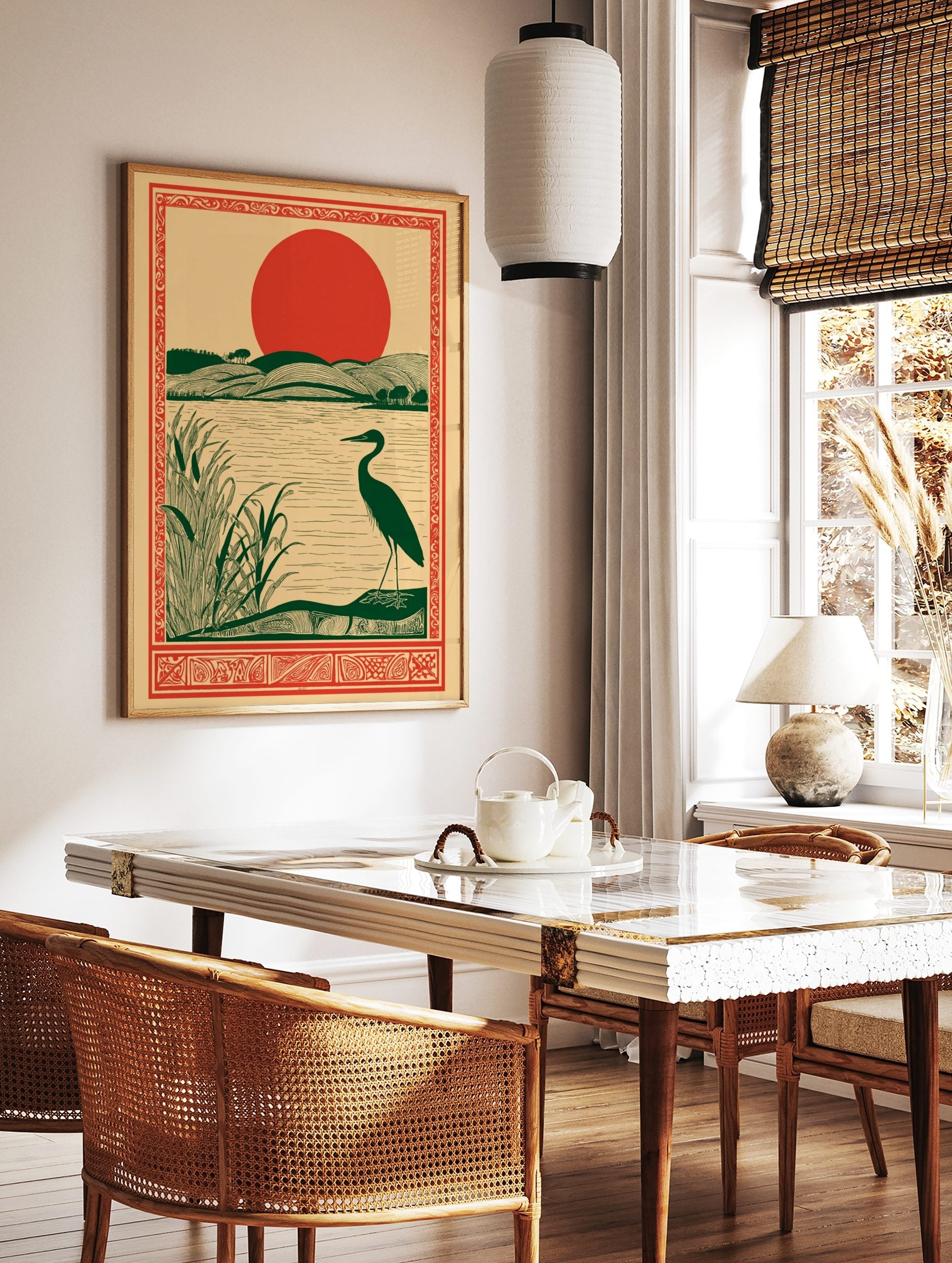 Illustrative art print of a dark green heron by a lake with reeds, rolling green hills, and a large, in a styled room mockup