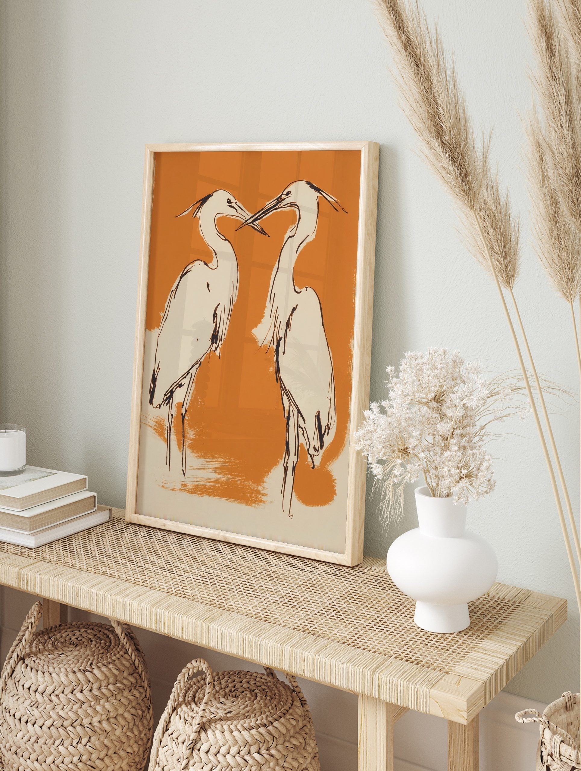 Illustrative art print of two herons with black outlines, cream bodies, on an orange, in an alternate framed mockup