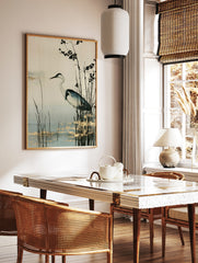 Heron bird standing in marsh reeds with gold leaf accents, neutral background wall art print, in a styled room mockup