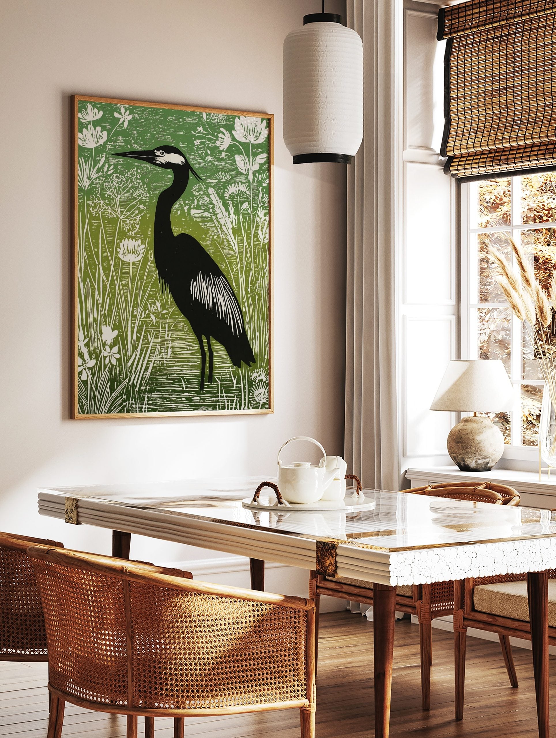 Illustrative green and black heron print standing in water amongst white botanical plants and reeds, in a styled room mockup