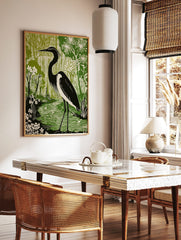Black and white heron standing in a green wetland with flowering plants, in a linocut style art, in a styled room mockup