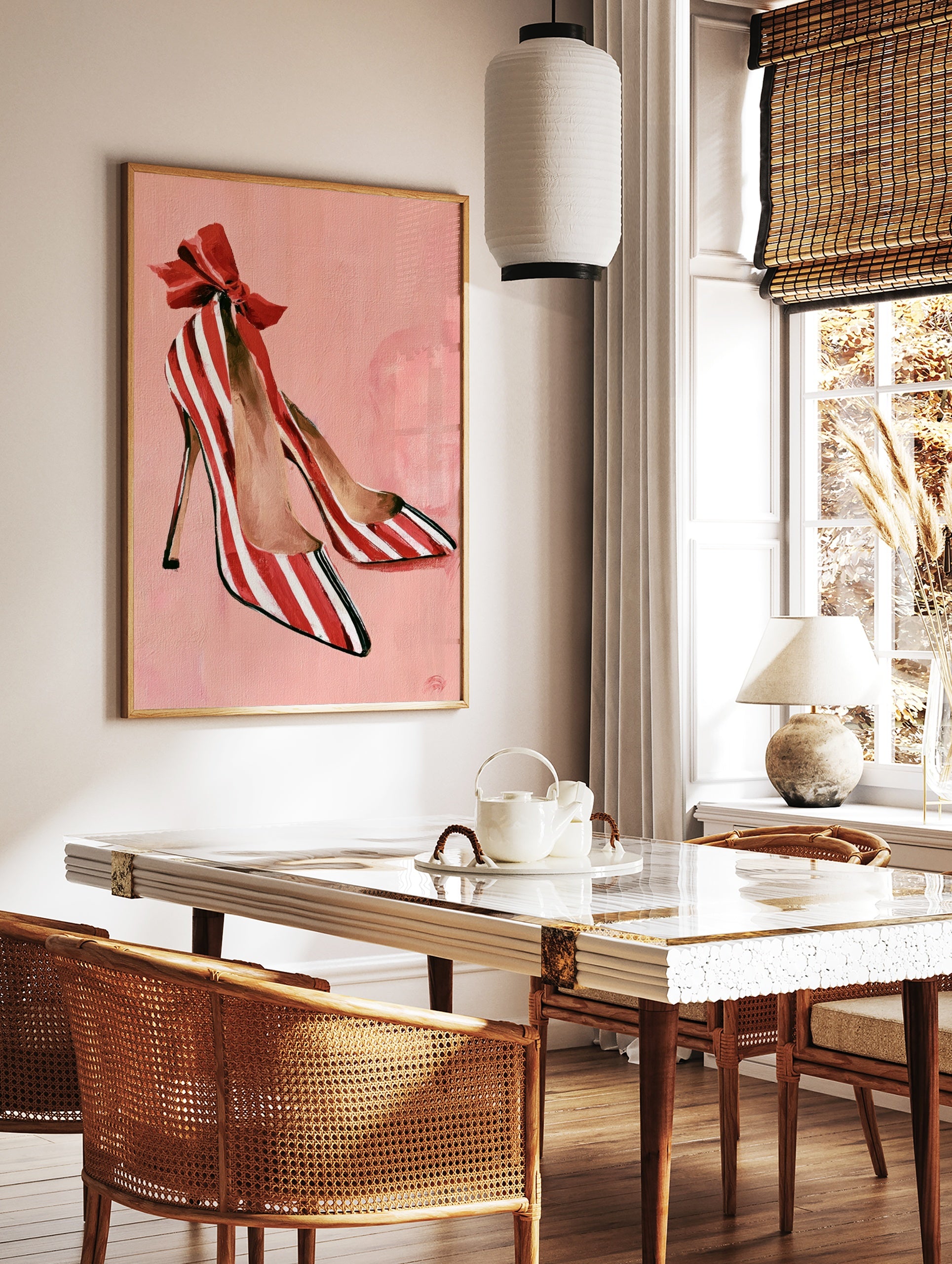 Illustrative print of red and white striped high heel shoes with a large red bow on a soft pink, in a styled room mockup