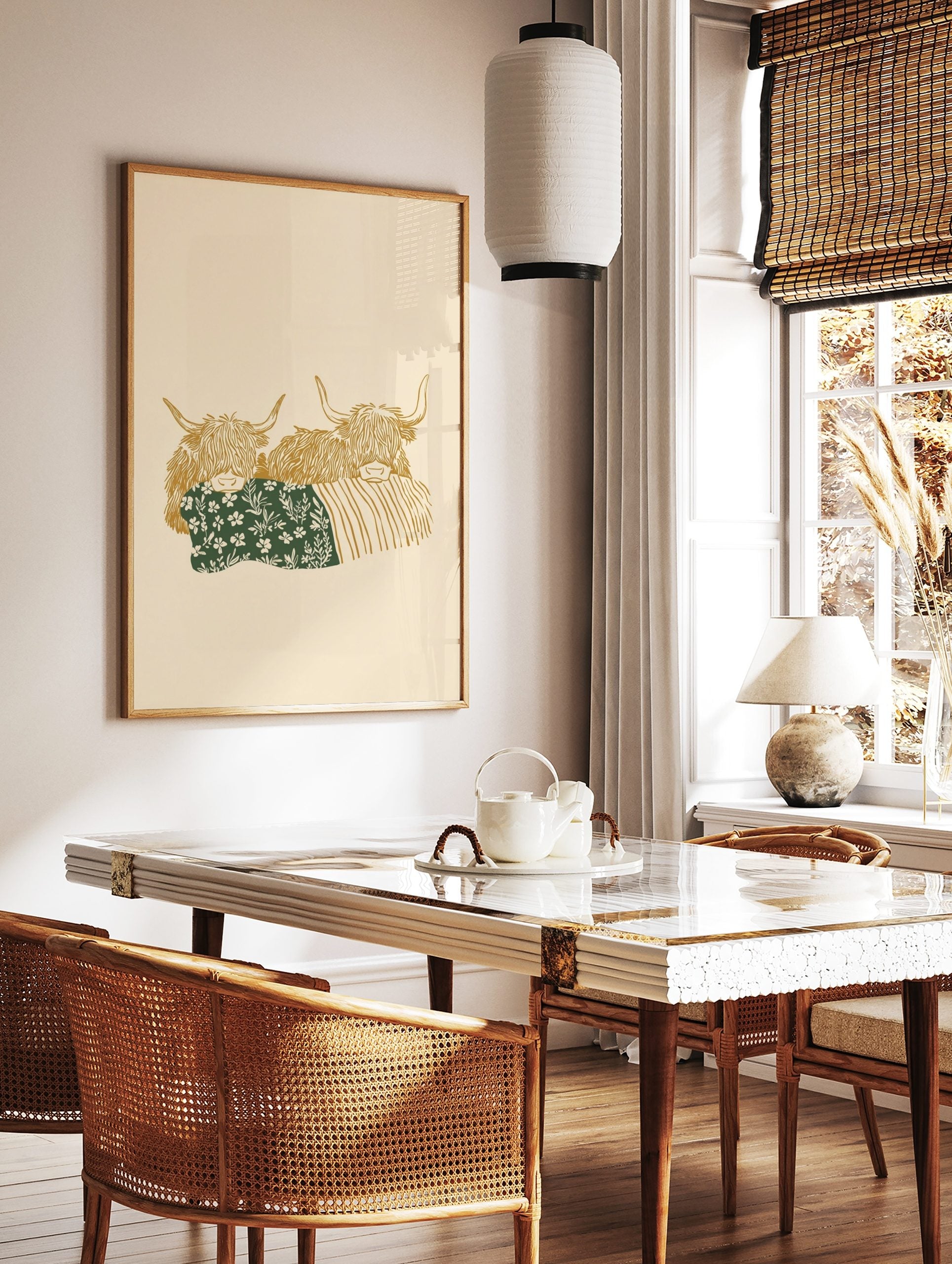 Illustrative art print of two golden Highland cows, one with a green floral blanket, on a beige, in a styled room mockup