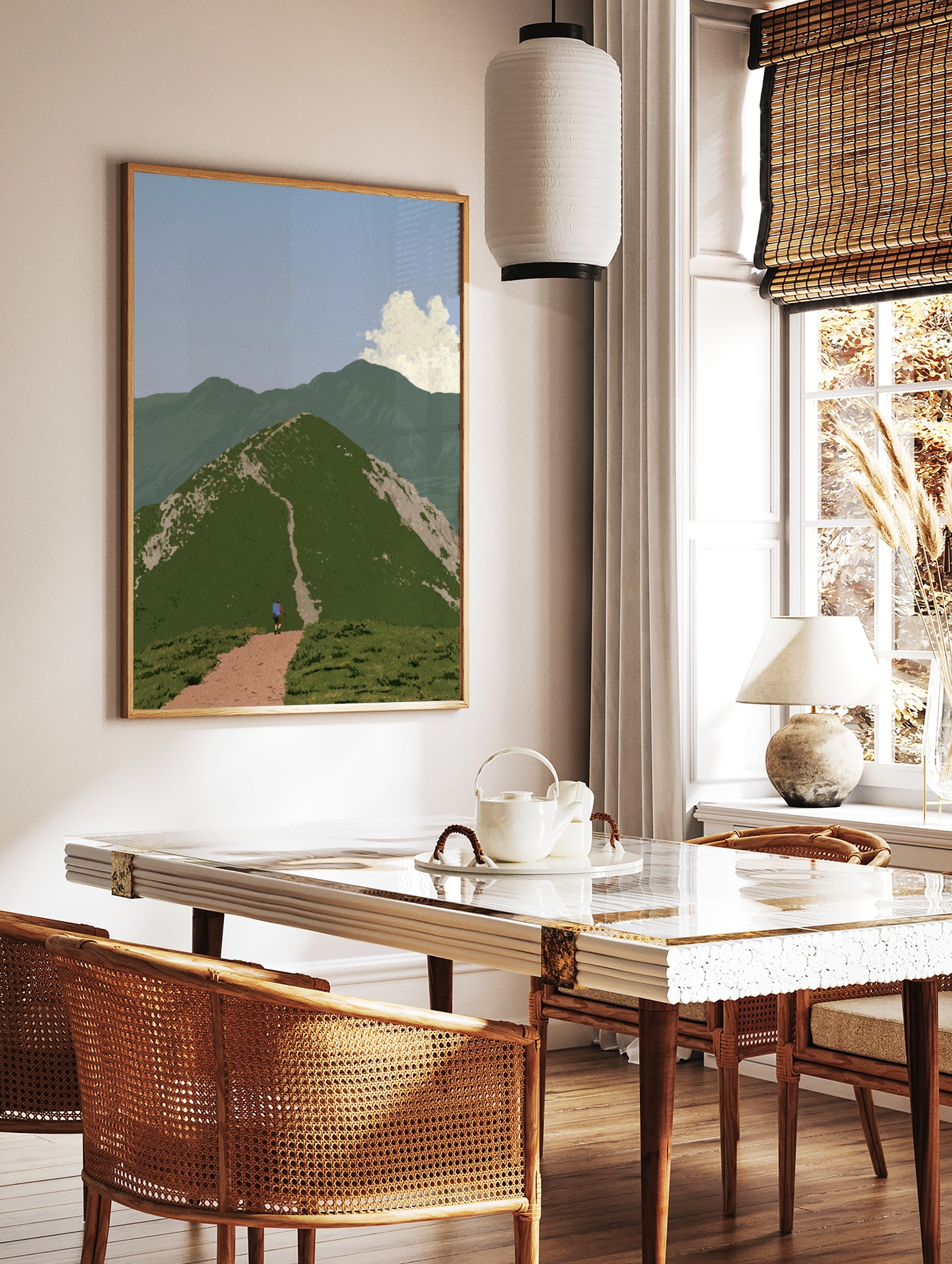 Hiker walking up a green mountain path towards a summit in a serene landscape art print, in a styled room mockup