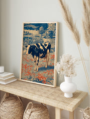 Holstein cow in a field of red flowers with blue trees and farmhouses in a vintage engraving, in an alternate framed mockup