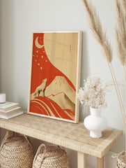 Illustrative art print of a howling wolf, crescent moon, stars, and Mount Fuji in red and, in an alternate framed mockup