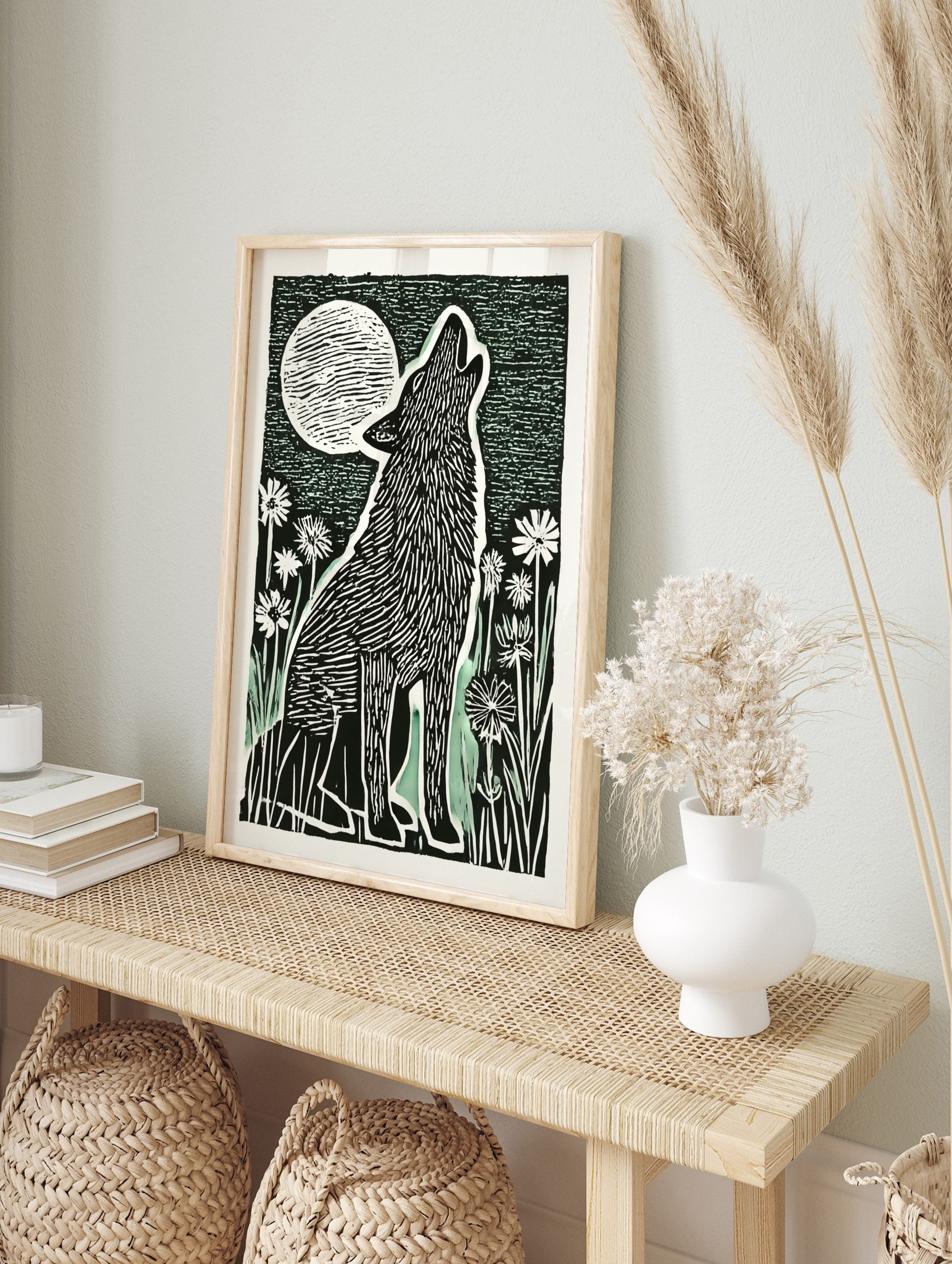 Illustrative black and white block print of a howling wolf under a large, striped full moon, in an alternate framed mockup