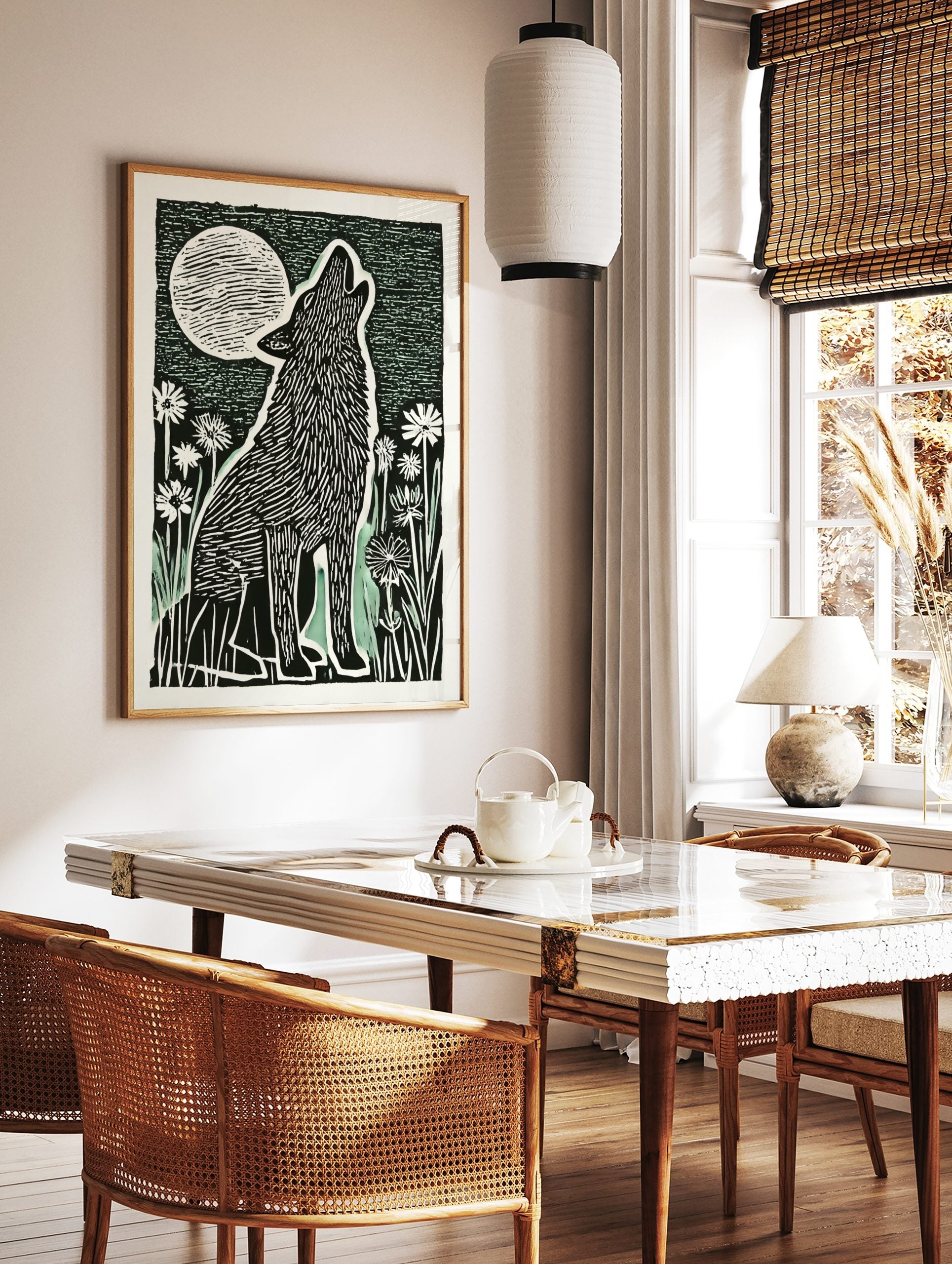 Illustrative black and white block print of a howling wolf under a large, striped full moon with, in a styled room mockup