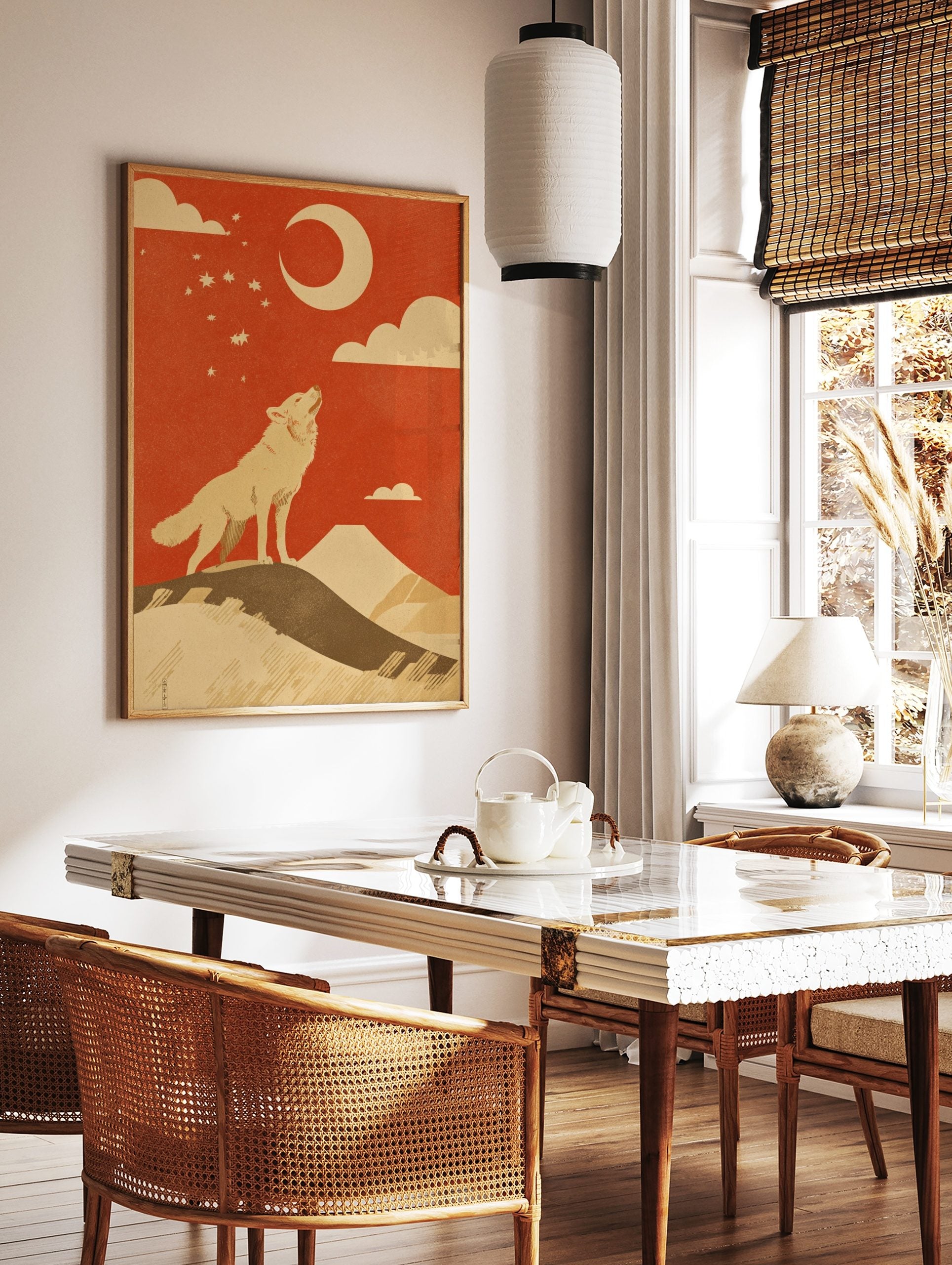Illustrative print of a howling wolf on a hill, looking up at a crescent moon and stars against a, in a styled room mockup