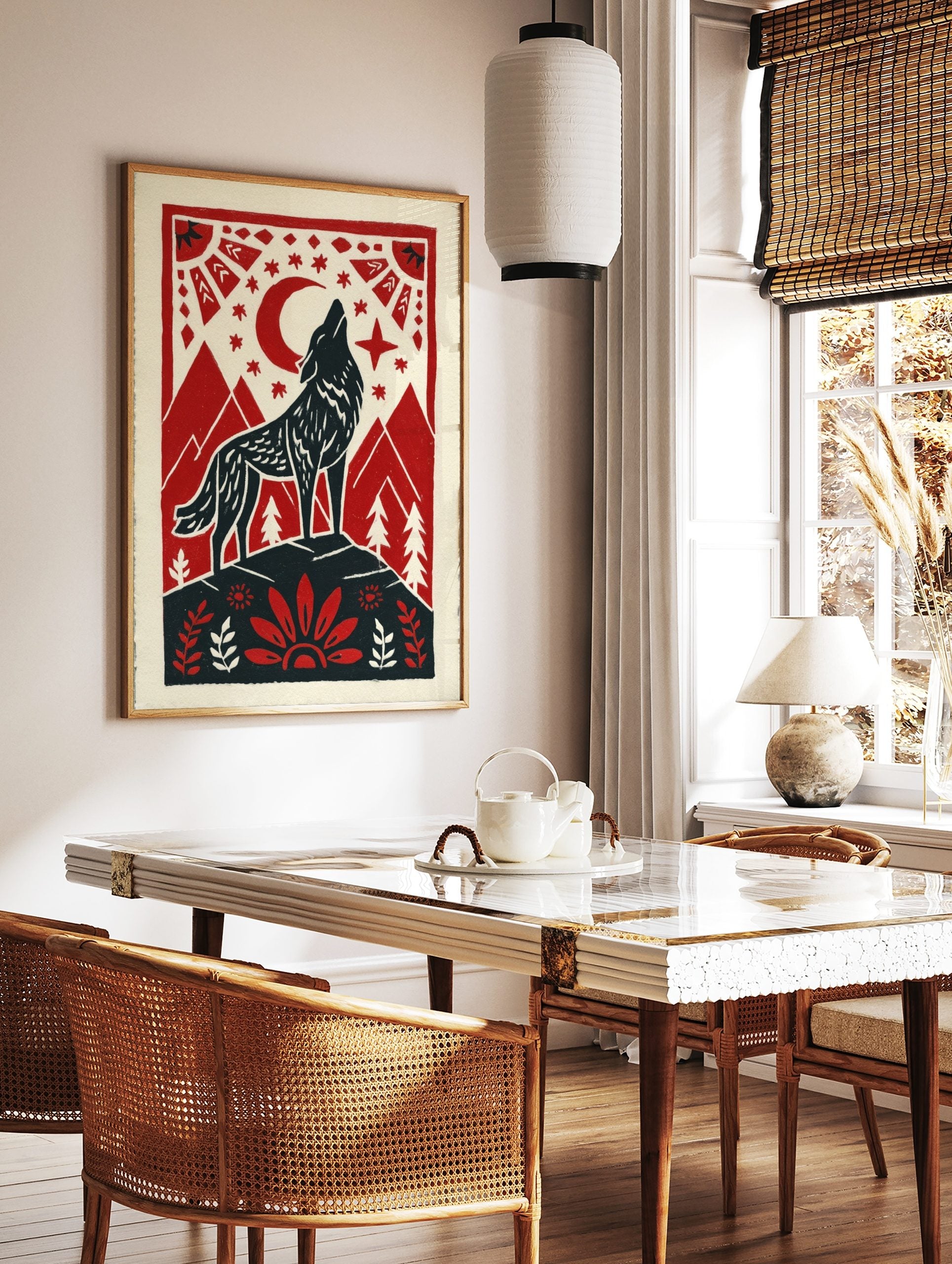Howling wolf against red moon and stars, framed by mountains and folk art border in red, black, in a styled room mockup