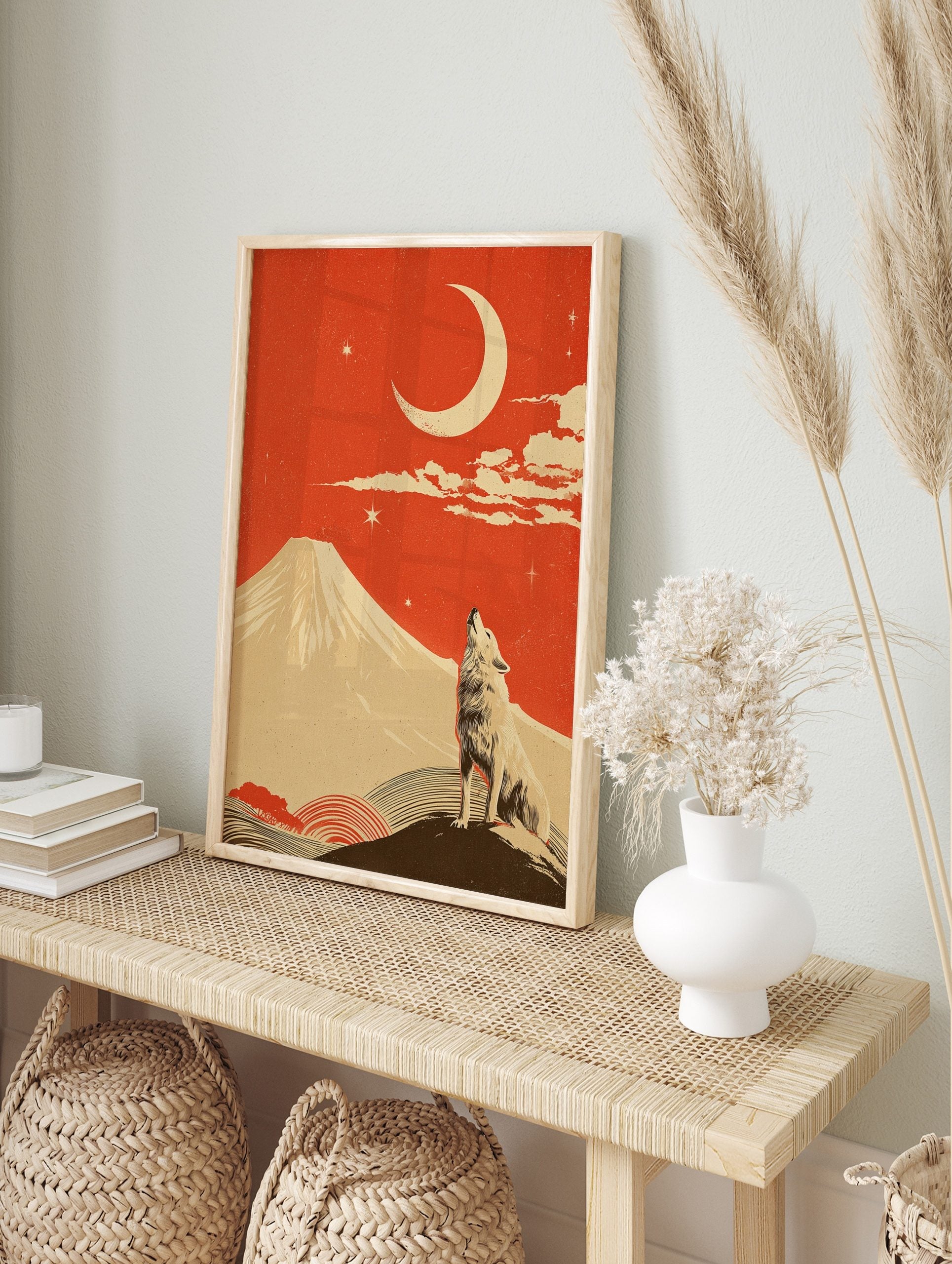 Illustrative print of a howling wolf, a large crescent moon, and a snow-capped mountain under, in an alternate framed mockup