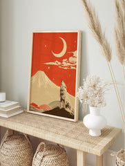 Illustrative print of a howling wolf, a large crescent moon, and a snow-capped mountain under, in an alternate framed mockup