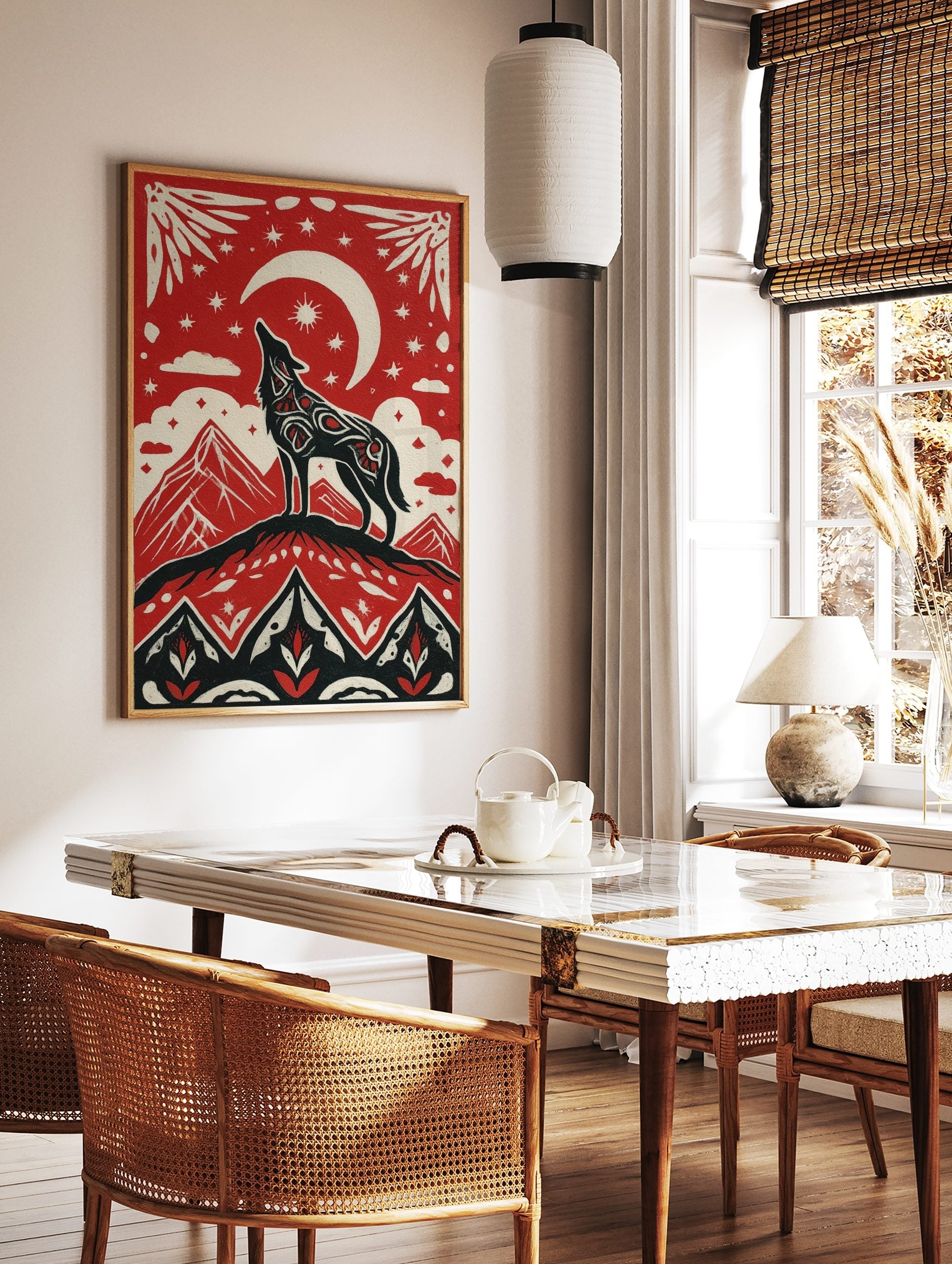 Illustrative red, black, and off-white art print of a howling wolf on a mountain under a crescent, in a styled room mockup