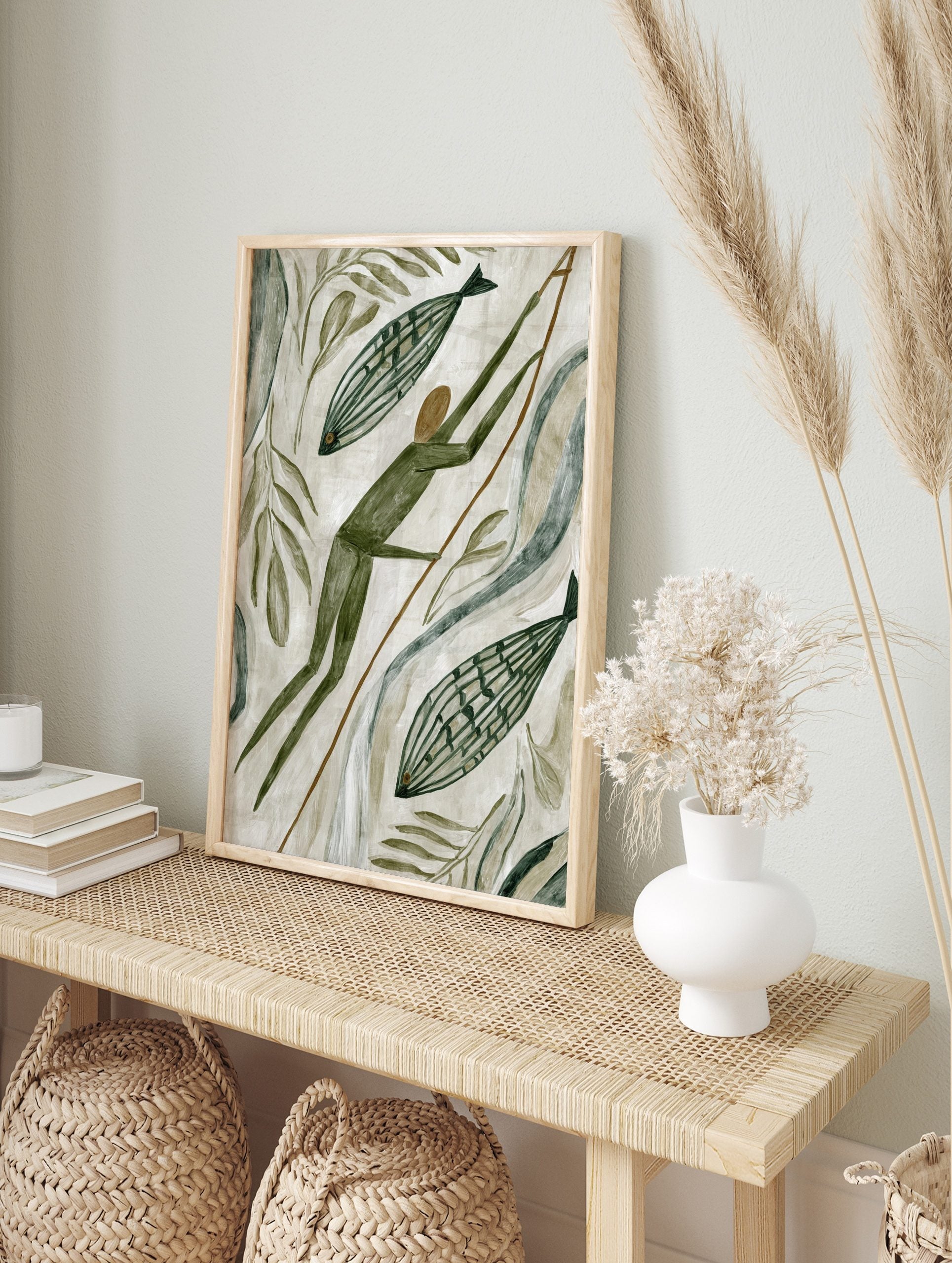 Primitive style hunter with spear and two striped fish, surrounded by green leaves and, in an alternate framed mockup